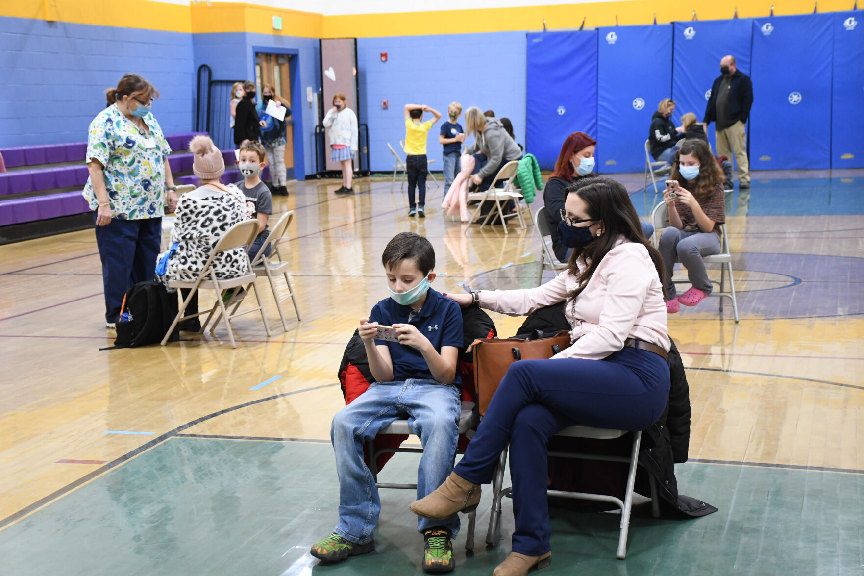 Children wait with their parents after getting the vaccine